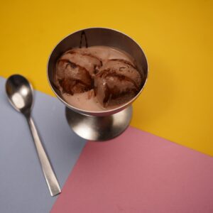 pexels-photo-20446421-20446421 Delicious chocolate ice cream served in a metal cup with a colorful geometric background, perfect for food photography.