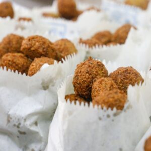 Close-up of freshly fried falafel served in paper wraps, capturing its crispy texture.