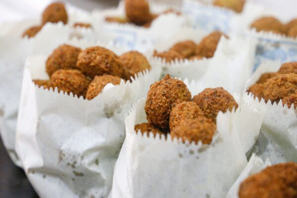 pexels-photo-3804003-3804003 Close-up of freshly fried falafel served in paper wraps, capturing its crispy texture.