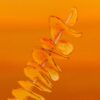 A visually appealing spiral potato skewer with a vibrant yellow background offering ample copy space.